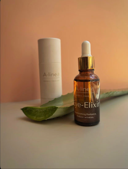 A-line Eye Elixir natural eye serum in an amber dropper bottle beside aloe vera and its packaging.