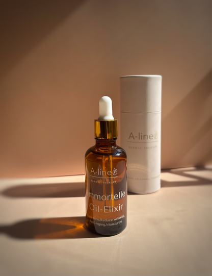 A-Line Immortelle Oil Elixir in a 50 ml bottle displayed with immortelle flowers and product packaging.